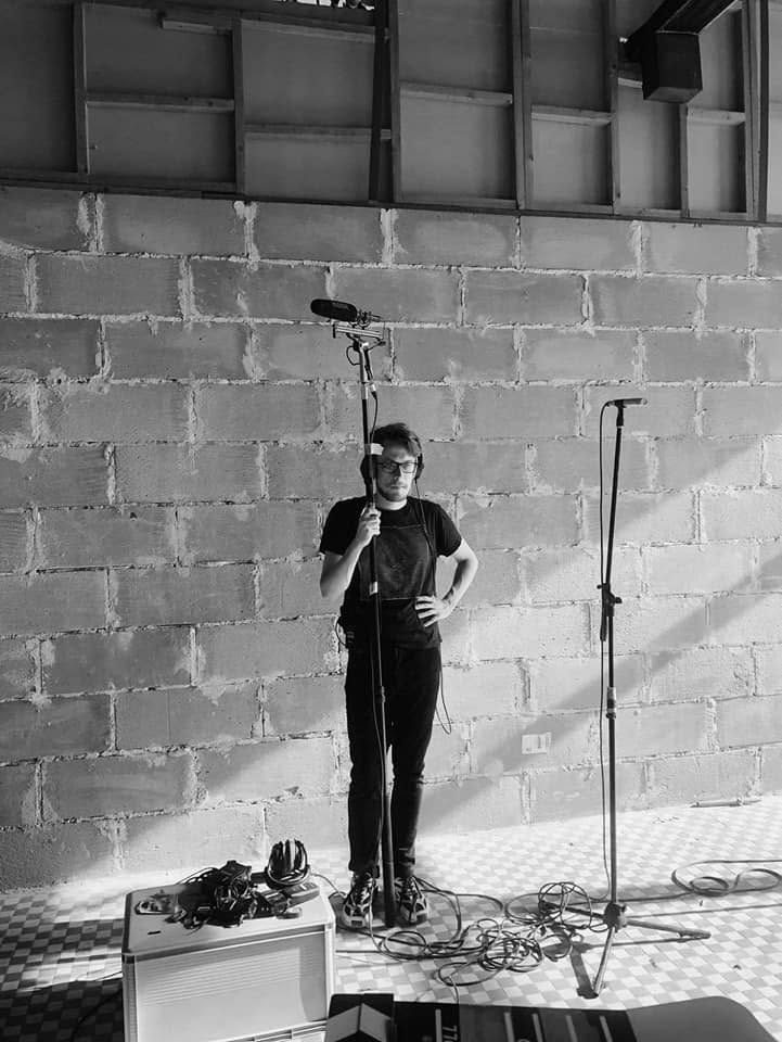 Recording a live performance: microphone on a stand and a small mixer at the front of the stage.