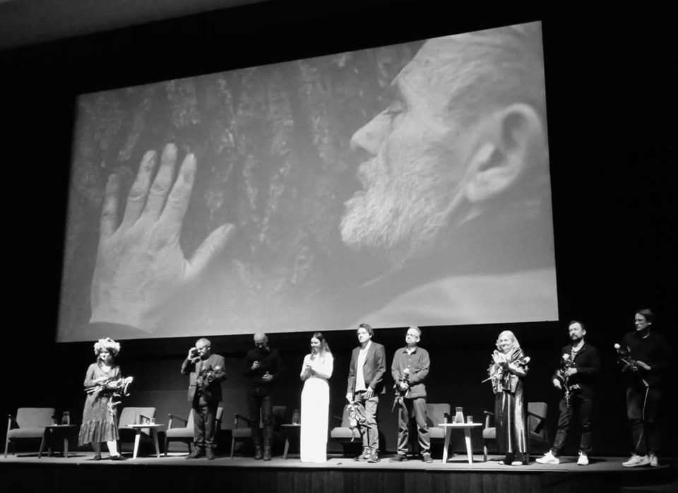A cinema screening with the film's crew on stage in front of the screen.
